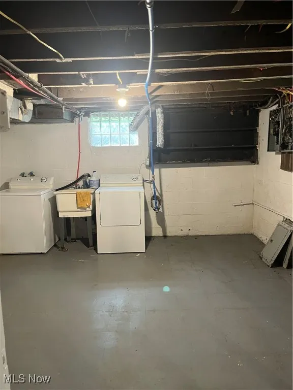 Basement featuring independent washer and dryer and a sink
