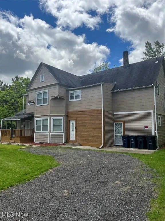 View of front of house featuring a chimney and a front lawn