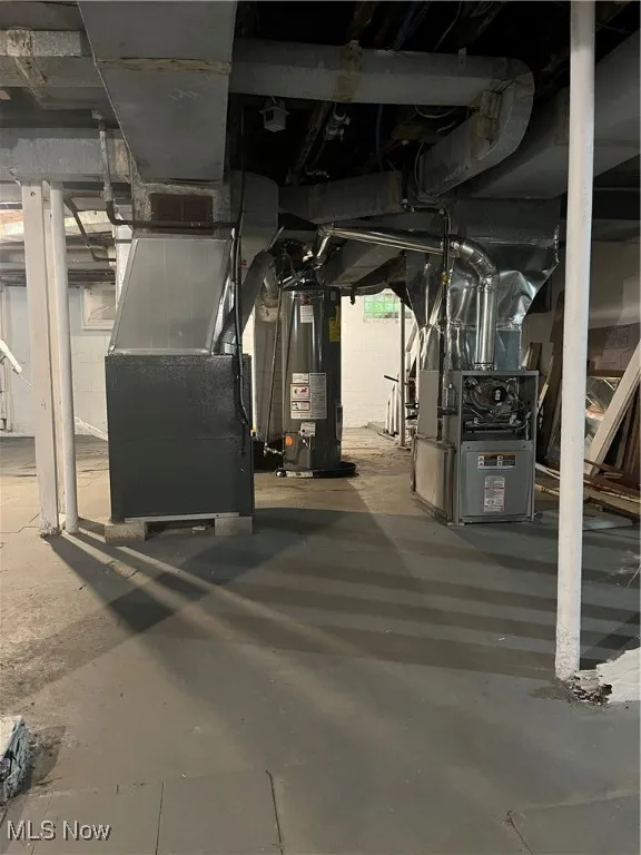 Unfinished below grade area featuring gas water heater and heating unit