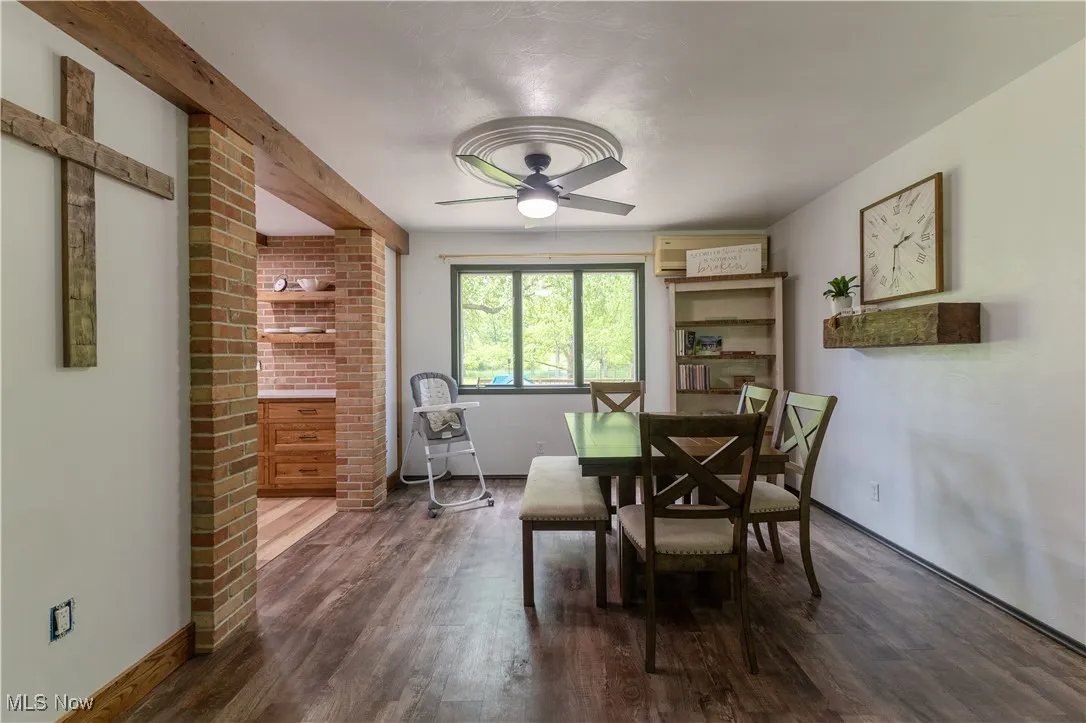 Dining area with a ceiling fan, dark wood-style floors, and baseboards