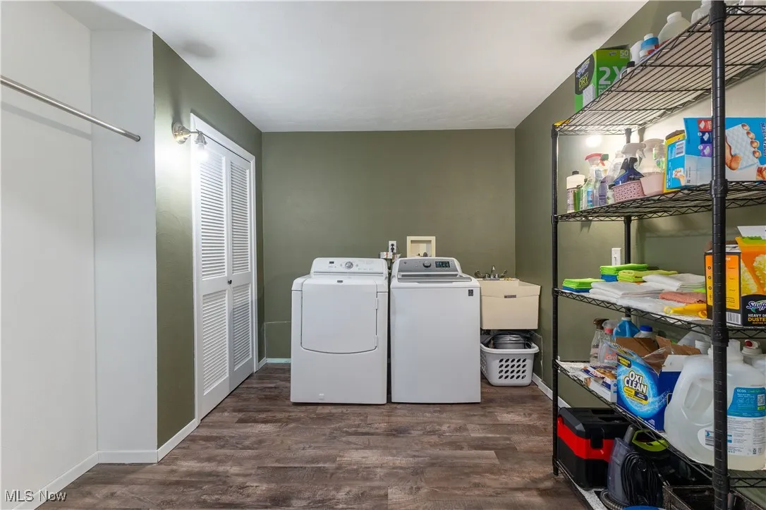 Laundry room with washing machine and clothes dryer, wood finished floors, and baseboards