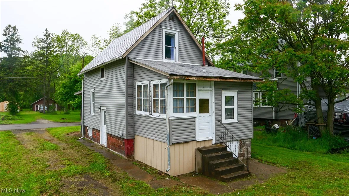 Rear view of house featuring entry steps and a shingled roof