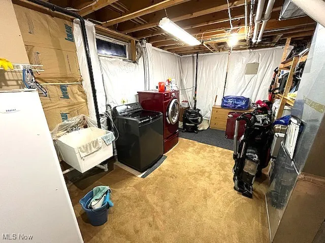 Unfinished basement featuring washing machine and dryer and carpet