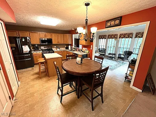 Dining area featuring a chandelier and a textured ceiling