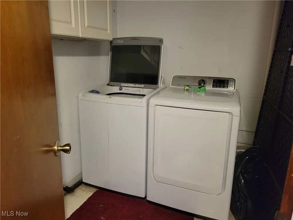 Washroom featuring separate washer and dryer and cabinet space