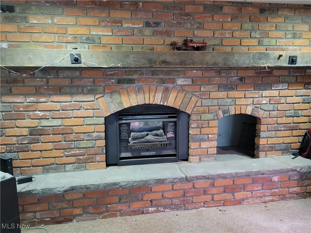 Detailed view of a brick fireplace and carpet flooring