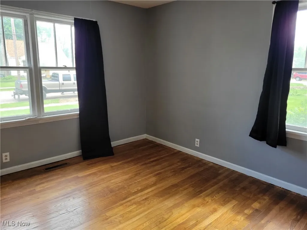 Unfurnished room featuring baseboards and light wood-type flooring