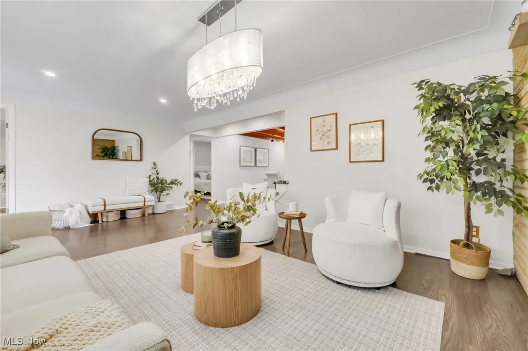 Living area featuring wood finished floors, recessed lighting, baseboards, and a chandelier