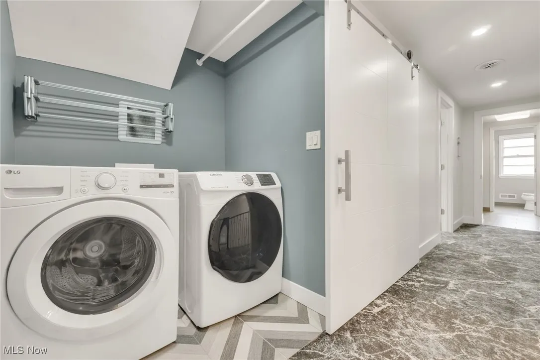 Laundry room with washing machine and clothes dryer, baseboards, and recessed lighting