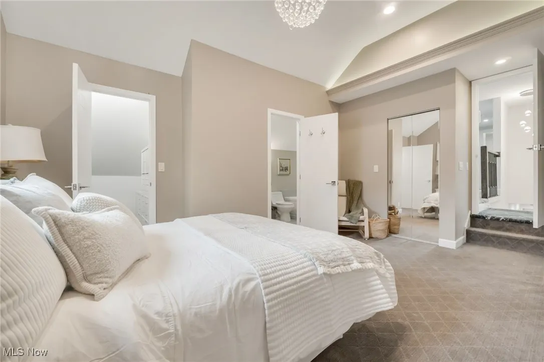 Carpeted bedroom with lofted ceiling, ensuite bathroom, and recessed lighting
