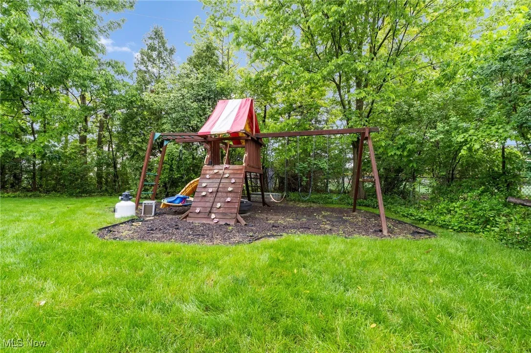 View of playground featuring a lawn and central air condition unit
