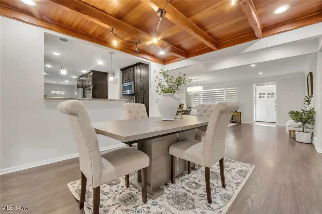 Dining space with wood ceiling with exposed beams, baseboards, wood finished floors, and recessed lighting