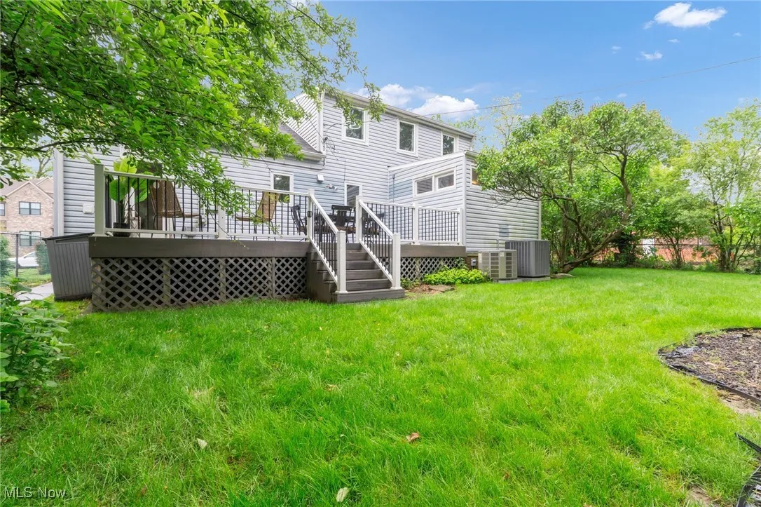 Rear view of property with central AC, a lawn, and a wooden deck