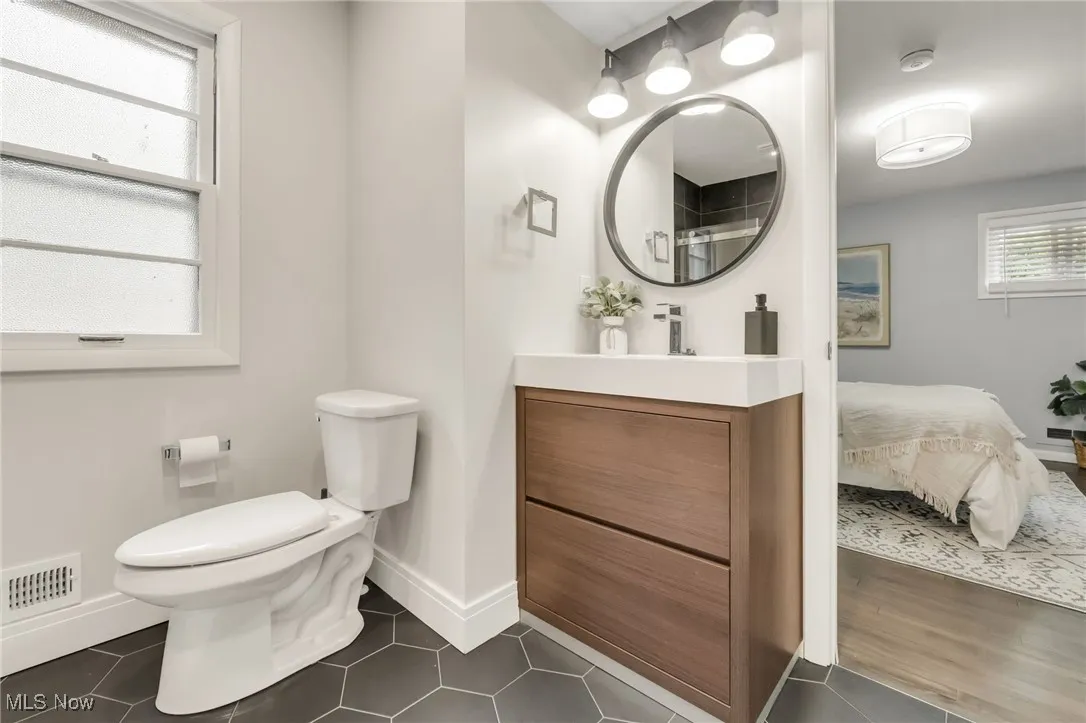 Bathroom with vanity, toilet, baseboards, and tile patterned floors