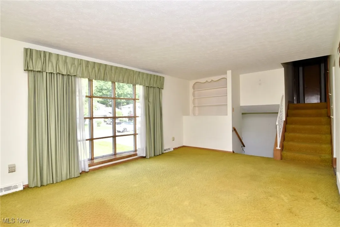 Carpeted empty room with a textured ceiling