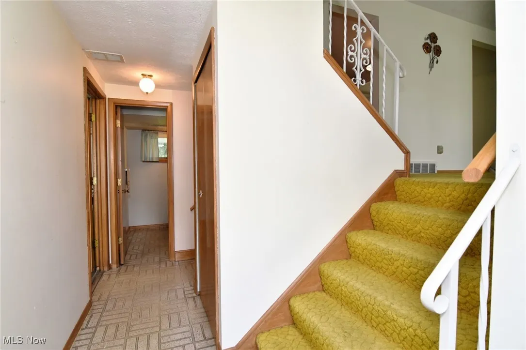 Stairway featuring baseboards and brick patterned flooring