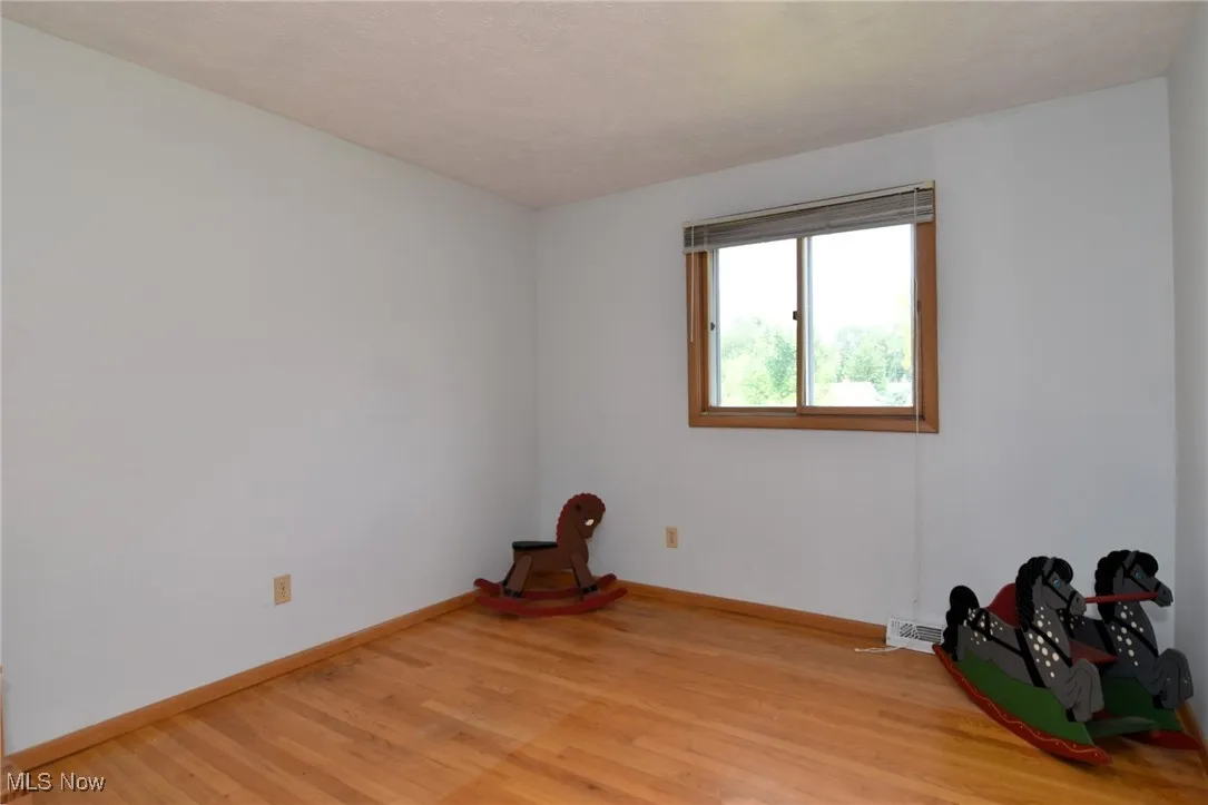 Spare room with light wood-style floors and baseboards