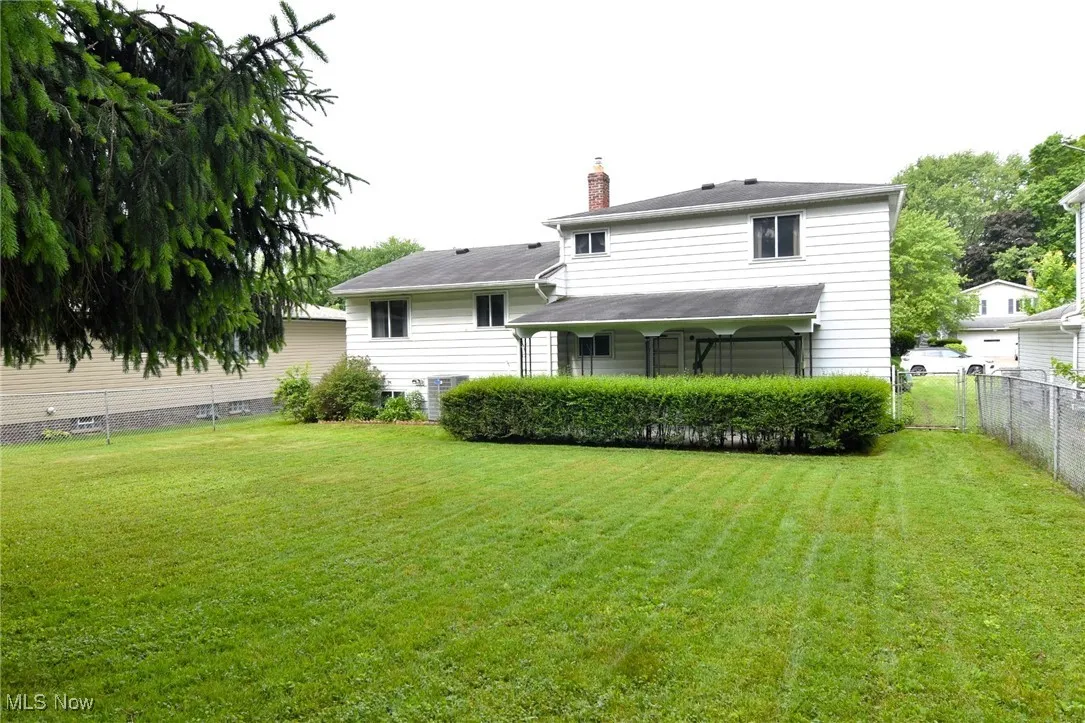 Back of property with a chimney and central AC unit