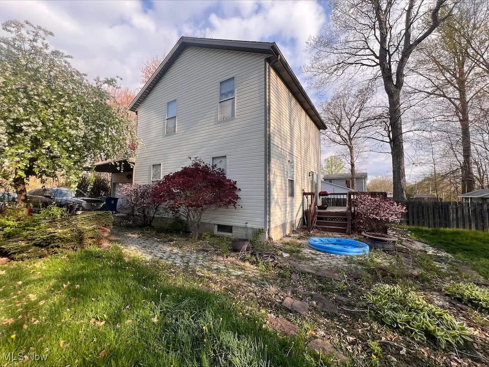 View of side of home featuring a wooden deck