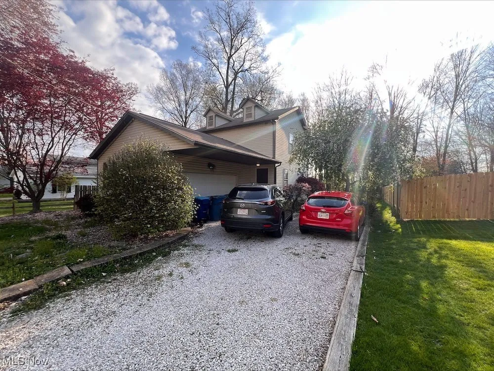 View of side of property featuring an attached garage and driveway