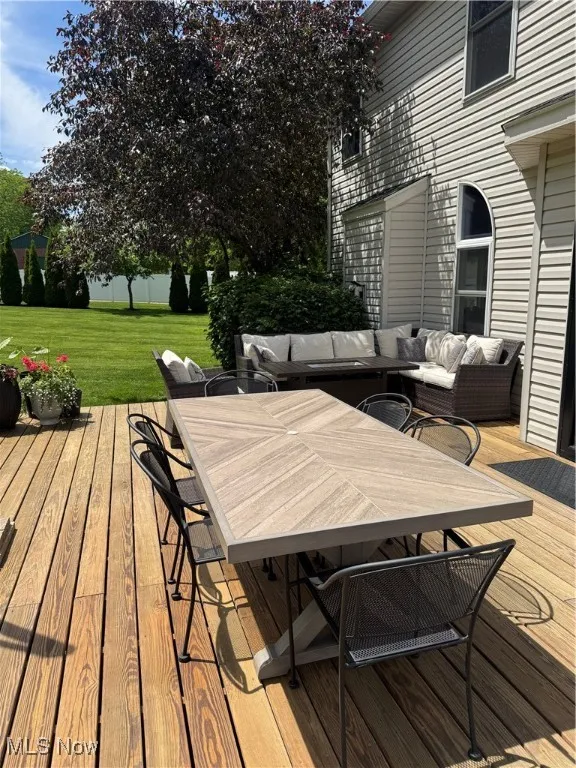 Deck with a yard, outdoor dining space, and an outdoor hangout area