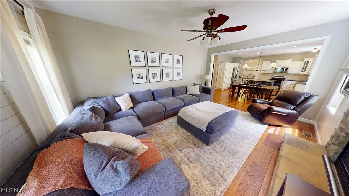 Living area featuring wood finished floors, ceiling fan, and recessed lighting