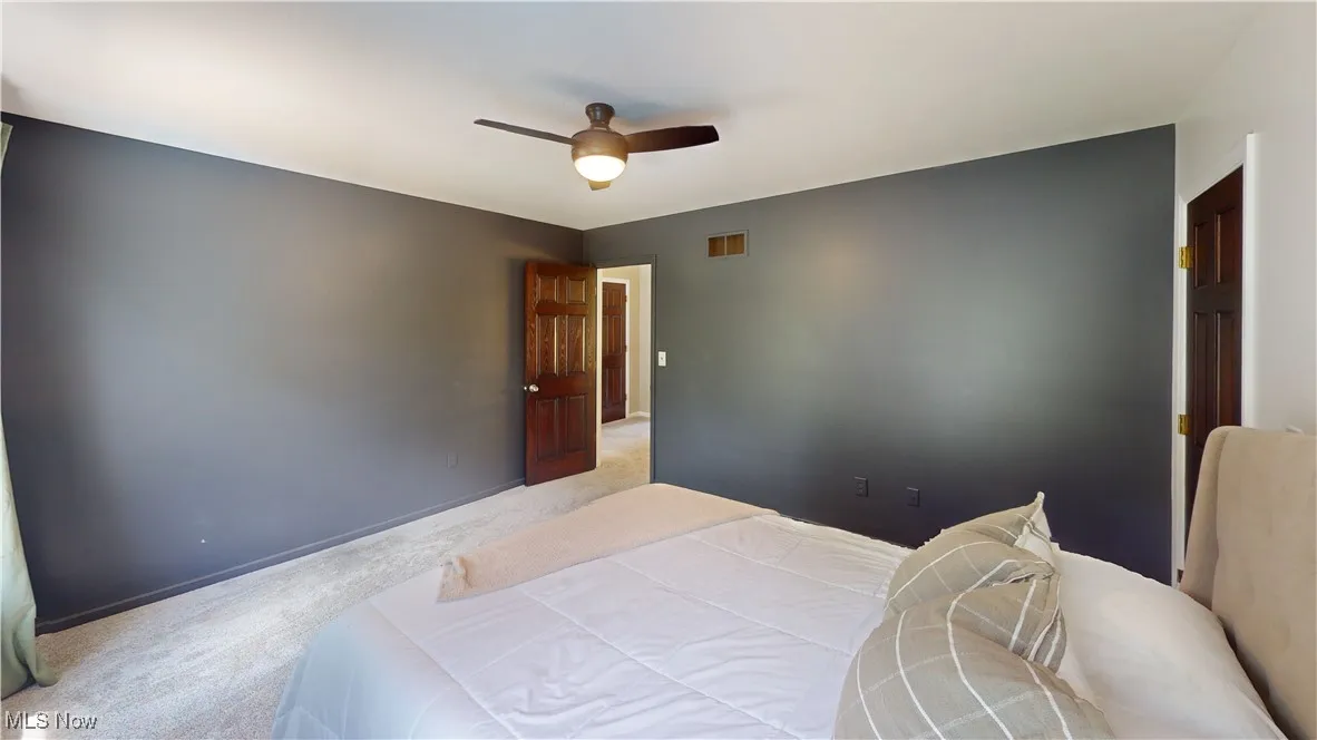 Carpeted bedroom with ceiling fan