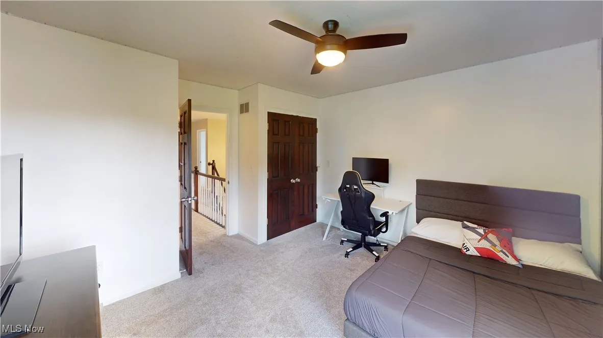 Bedroom with carpet, a ceiling fan, and a desk