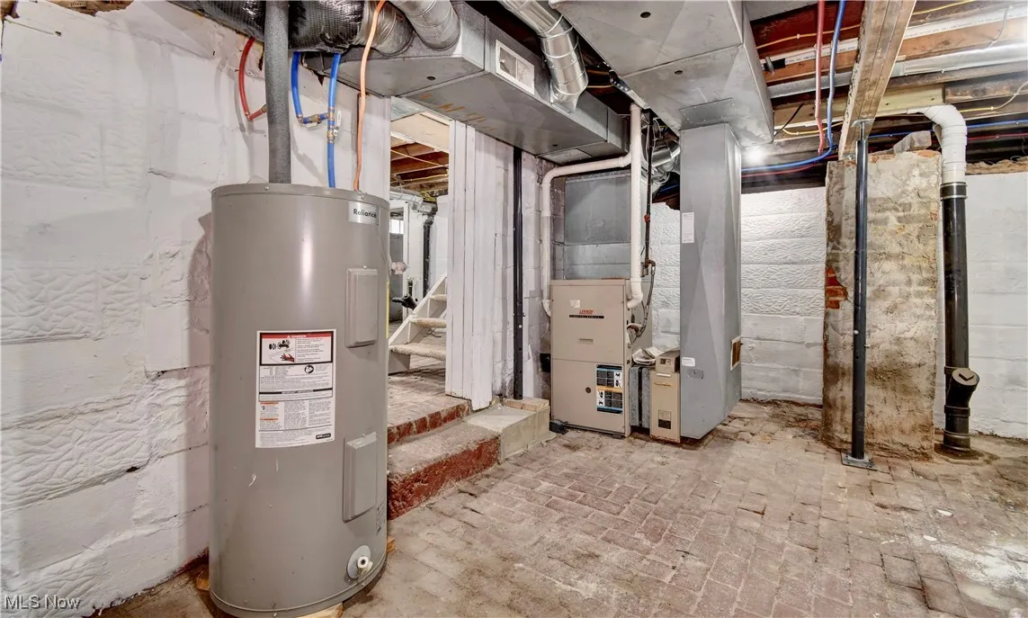 Utility room featuring electric water heater and heating unit