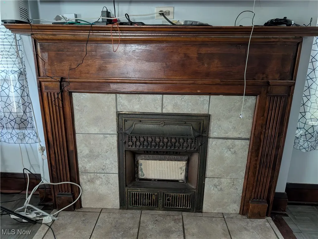 Detailed view of a tiled fireplace and baseboards