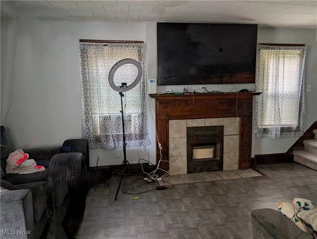 Living room with stairway, plenty of natural light, and a fireplace