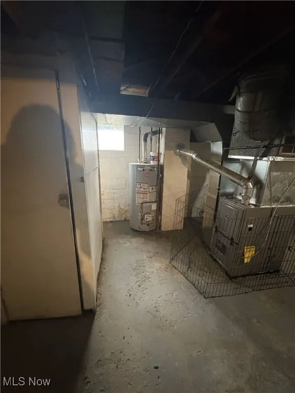 Basement featuring water heater and heating unit