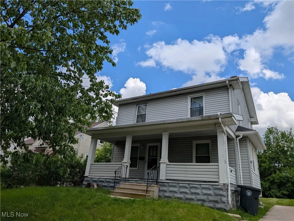 View of front facade with covered porch and a front yard