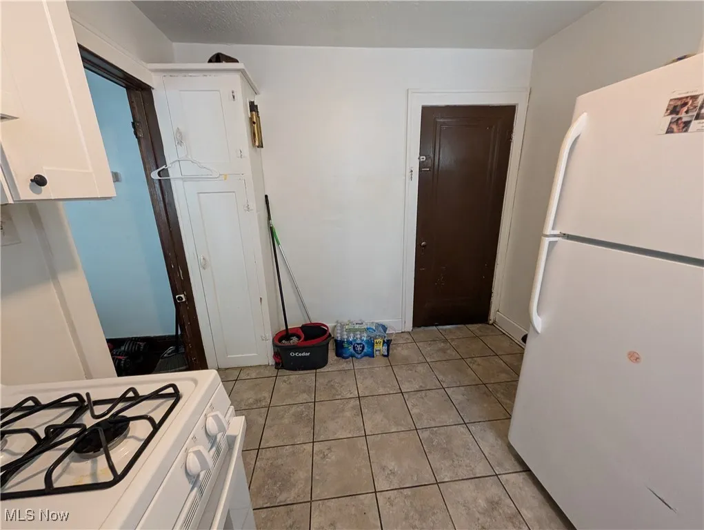 Kitchen with white appliances and light tile patterned floors