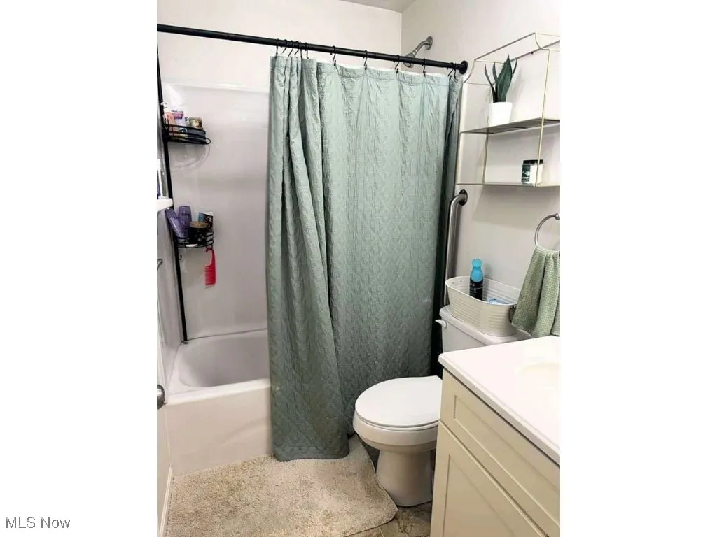 Full bath with vanity, toilet, shower / bath combo, and tile patterned floors