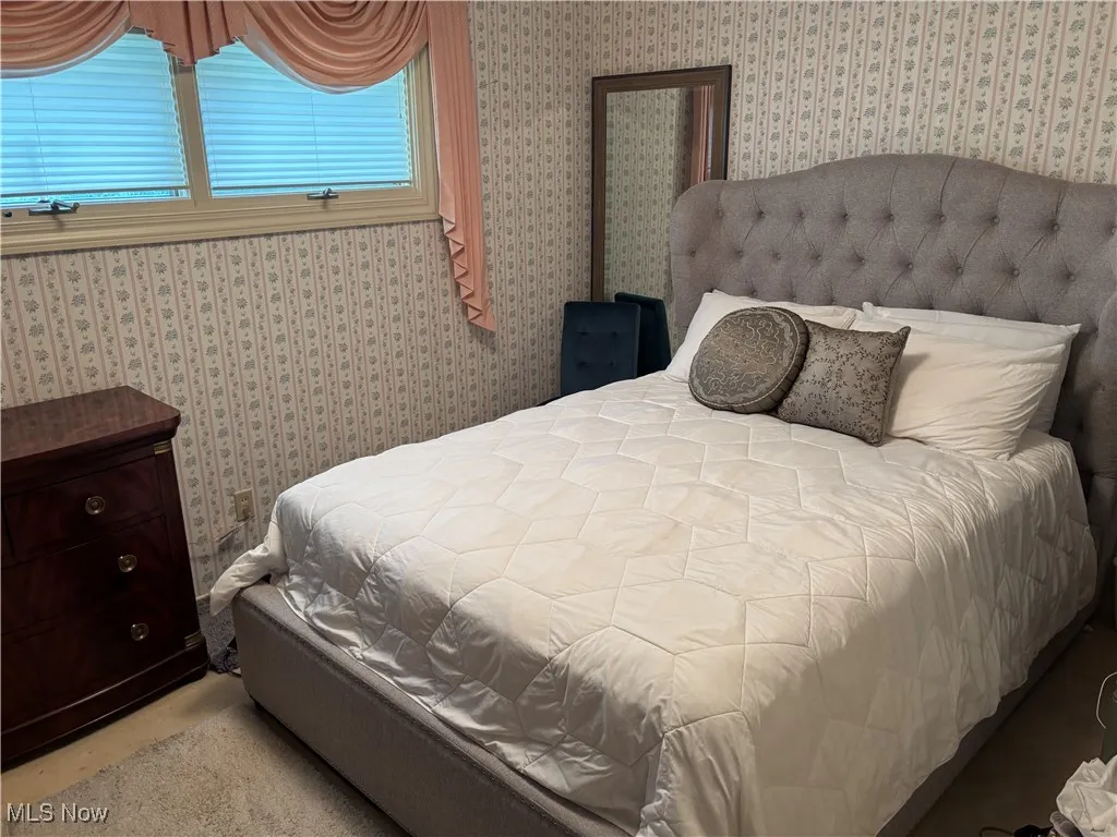 Bedroom featuring wallpapered walls