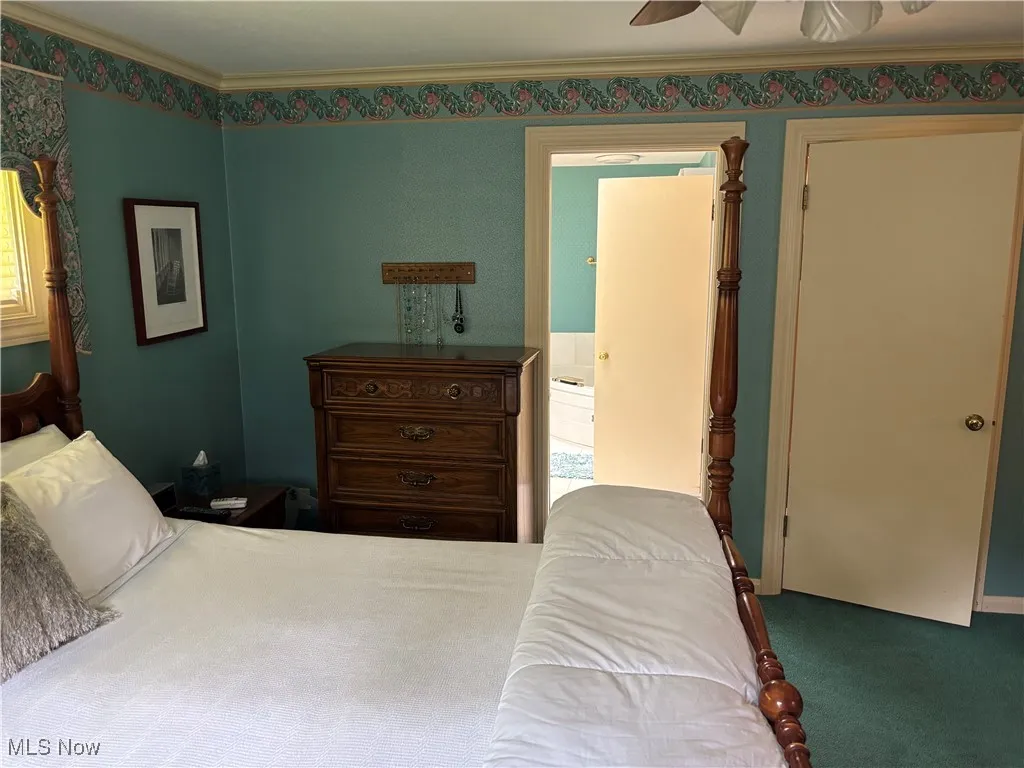 Carpeted bedroom with ornamental molding