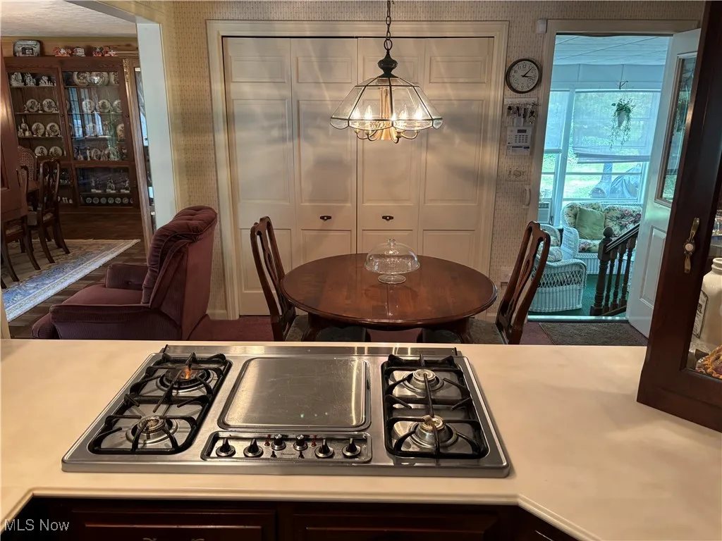 Dining space with wallpapered walls and a chandelier