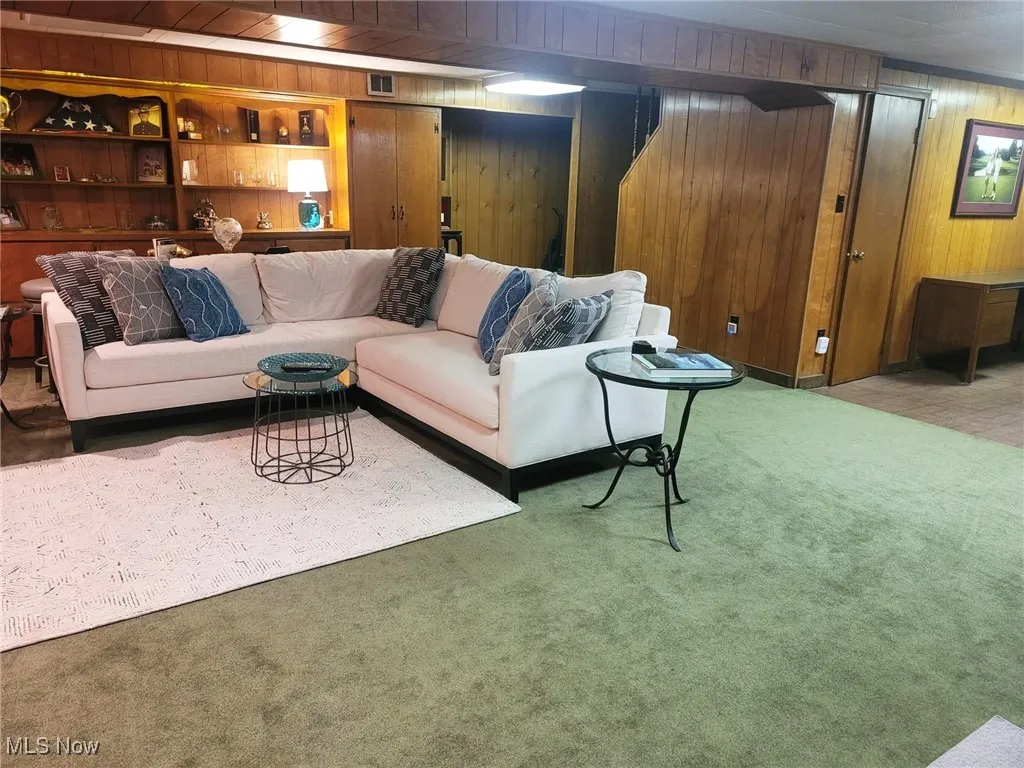 Living room with wood walls and carpet flooring