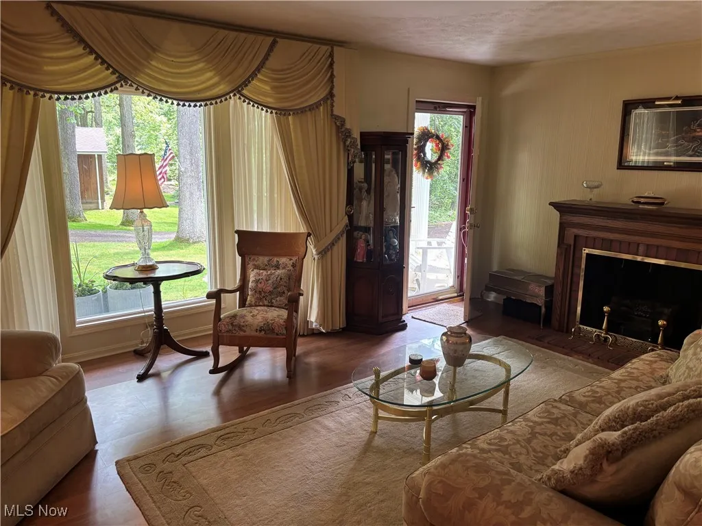 Living area with plenty of natural light, a fireplace with flush hearth, and wood finished floors