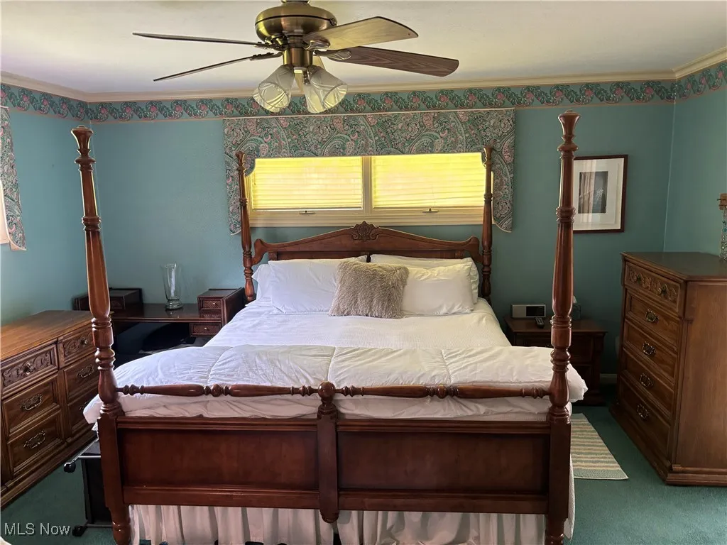 Bedroom featuring carpet floors, a ceiling fan, and ornamental molding