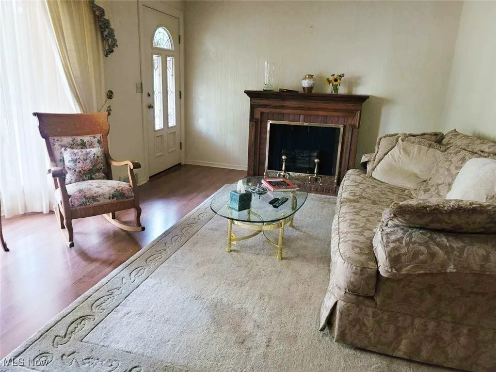 Living room featuring wood finished floors and a brick fireplace