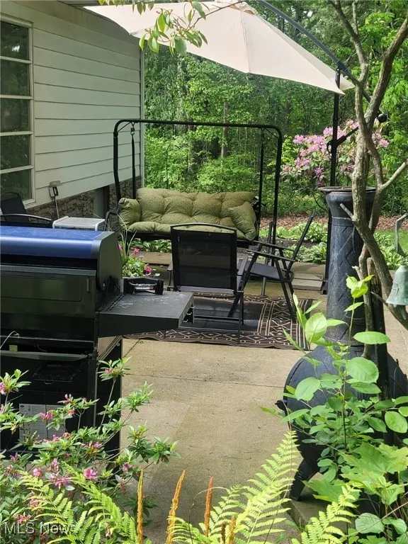 View of patio featuring an outdoor living space and a grill