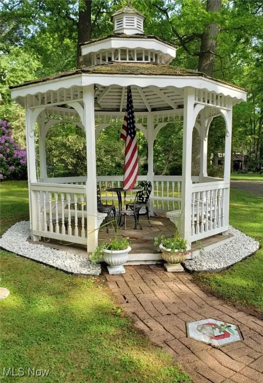 View of home's community featuring a gazebo, a lawn, and view of wooded area