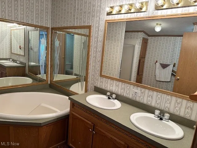 Full bath with a garden tub, a stall shower, double vanity, and toilet