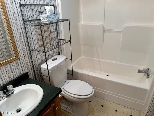 Full bath featuring vanity, toilet, tub / shower combination, and tile patterned floors