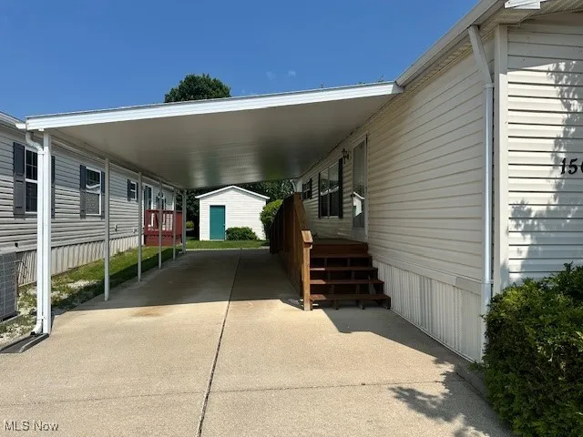 View of parking featuring an attached carport and driveway