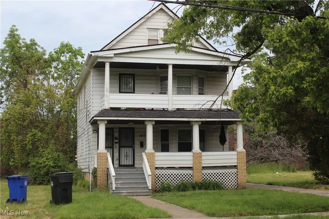 View of front of house featuring covered porch, a balcony, and a shingled roof
