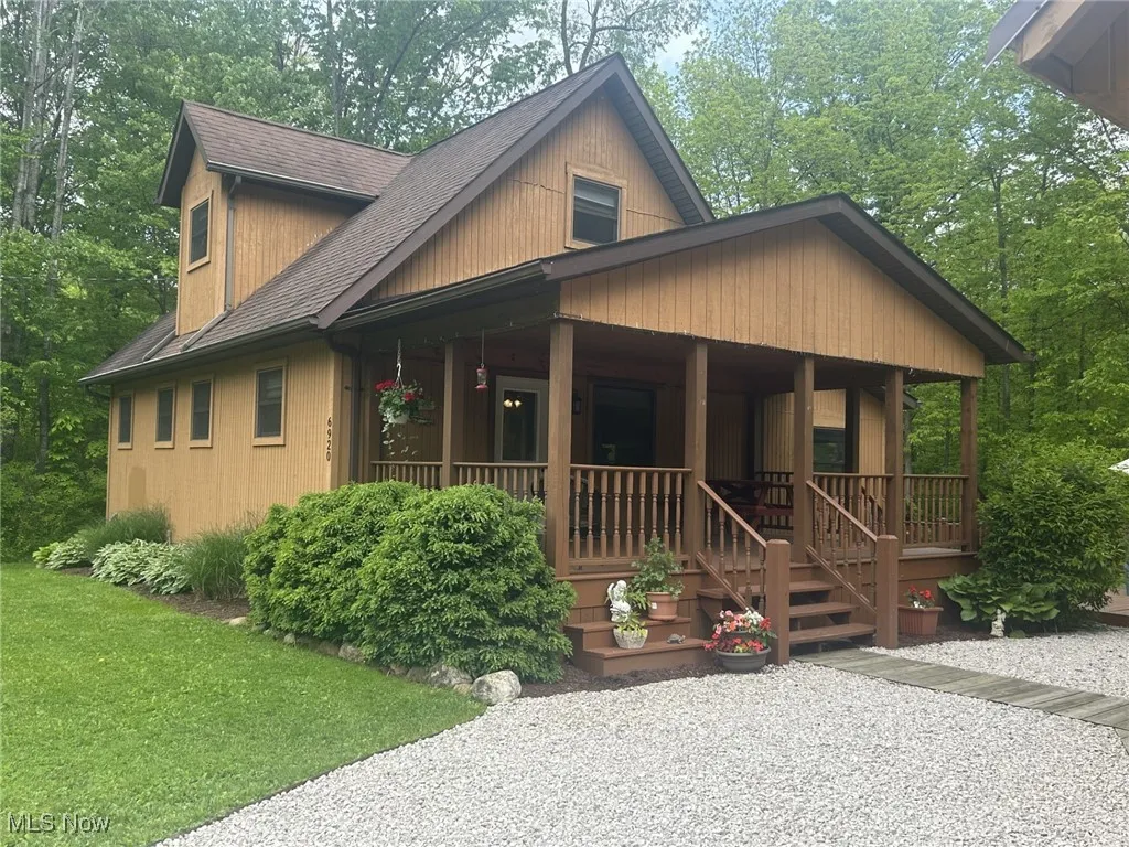 Chalet / cabin featuring a porch and roof with shingles