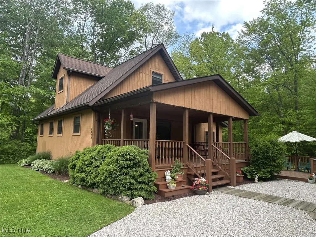 Rustic home featuring a porch, roof with shingles, and a front yard